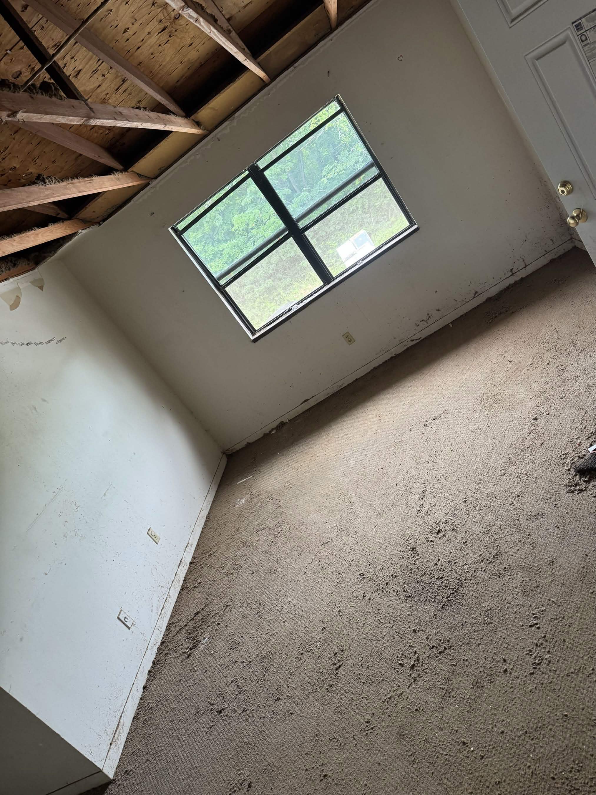Emptied room with a stripped ceiling after a full property cleanout by Titan Junk Removal