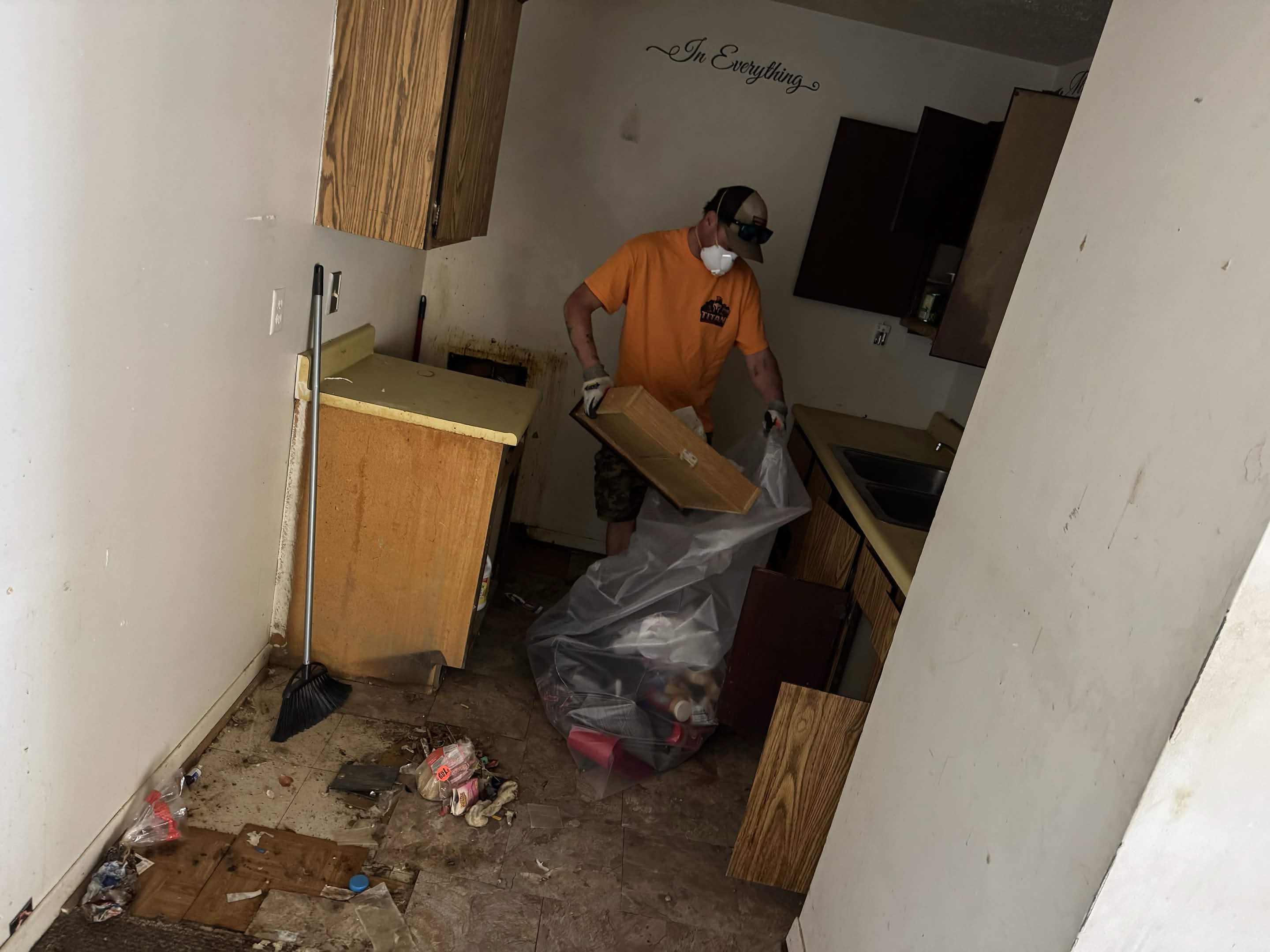Titan crew member bagging trash and clearing a kitchen during an estate cleanout